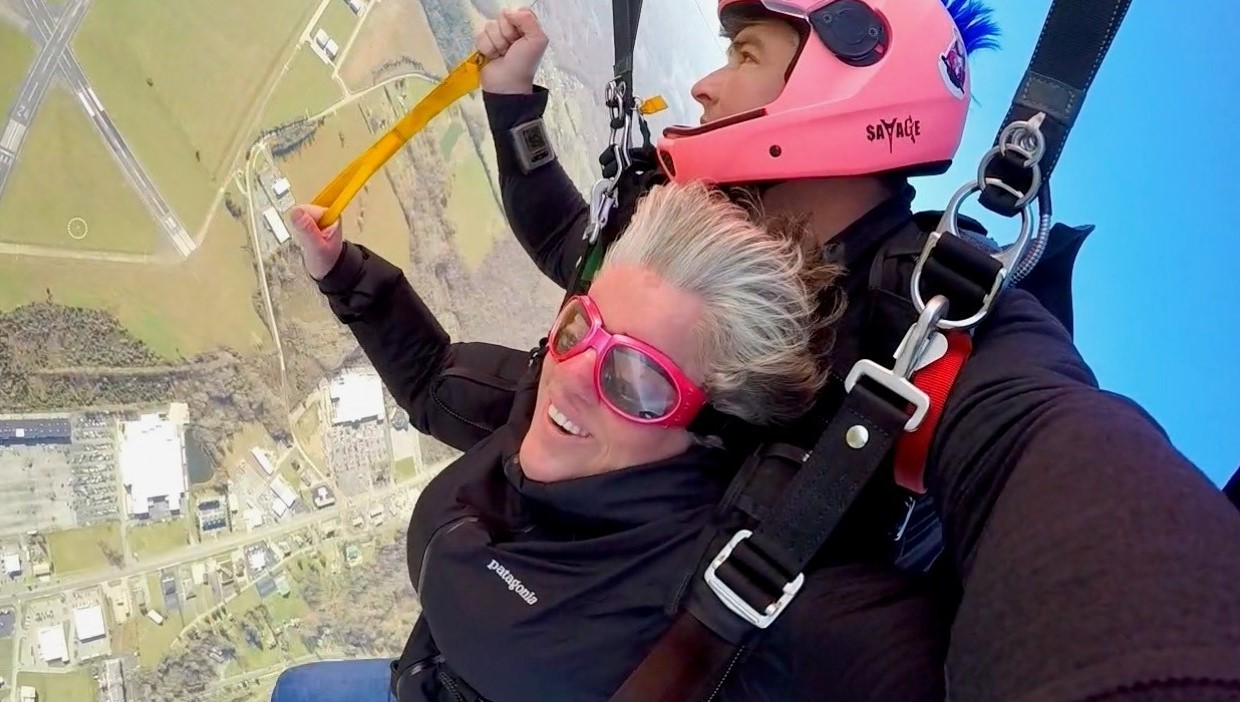 Sarah and instructor smile broadly for the camera mid-fall