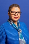 headshot of Cathlyn Smith, a Black woman with short brown hair, hoop earrings, a gold blazer and white blouse, and a state of TN pin
