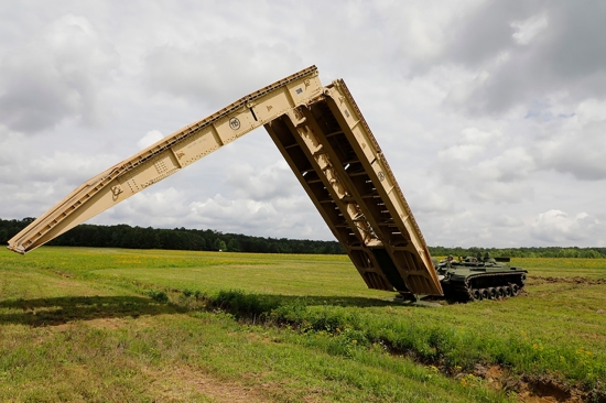 Tennessee Army National Guard Soldiers assigned to the 190th Engineer Company employ the M60 Armored Vehicle Launch Bridge over a simulated flooding stream at the Volunteer Training Site in Tullahoma, Saturday, May 18. As the bridge was deployed, the Soldiers worked together to ensure its stability and security, demonstrating their expertise in setting up critical infrastructure in challenging terrain. (U.S. Army National Guard photo by Sgt. First Class Mathieu Perry)