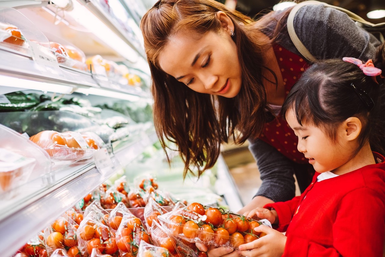 Mother and child shopping for fruit in the grocery store