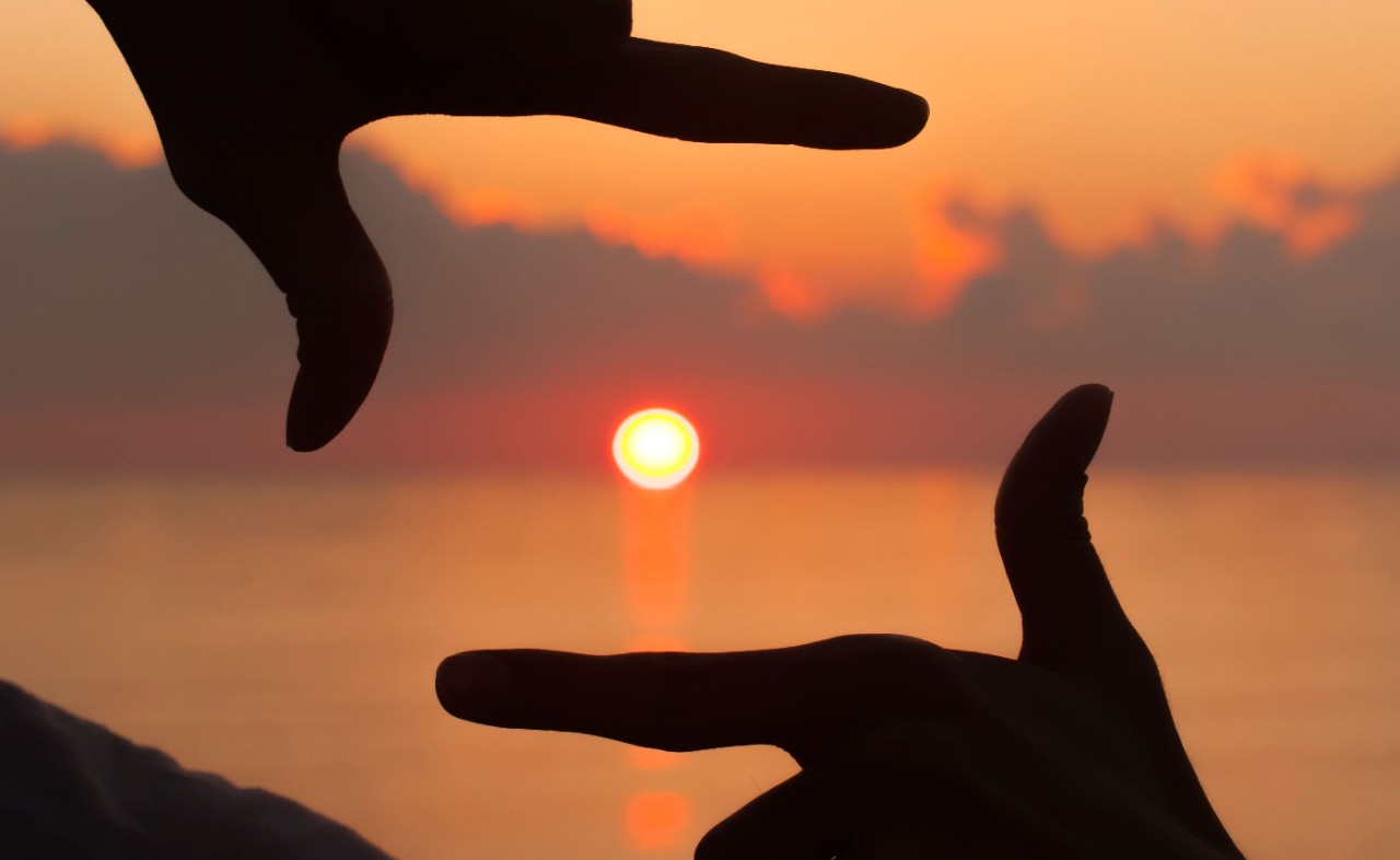 Framing ACEs Index fingers and thumb framing sun going down